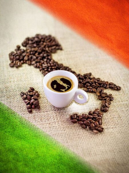 Caffè italiano: chicchi a forma d’Italia su sfondo tricolore con tazzina al centro